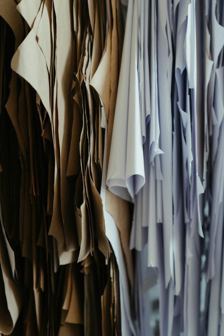 Detailed view of hanging fabric patterns in a fashion design workshop.